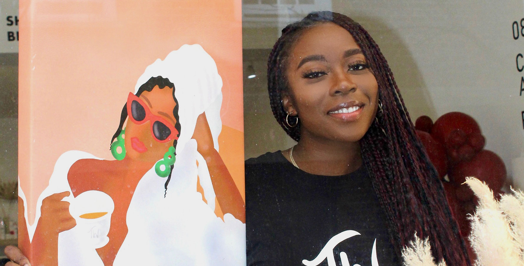 Toyosi Olowe smiling for the camera alongside her commissioned artwork