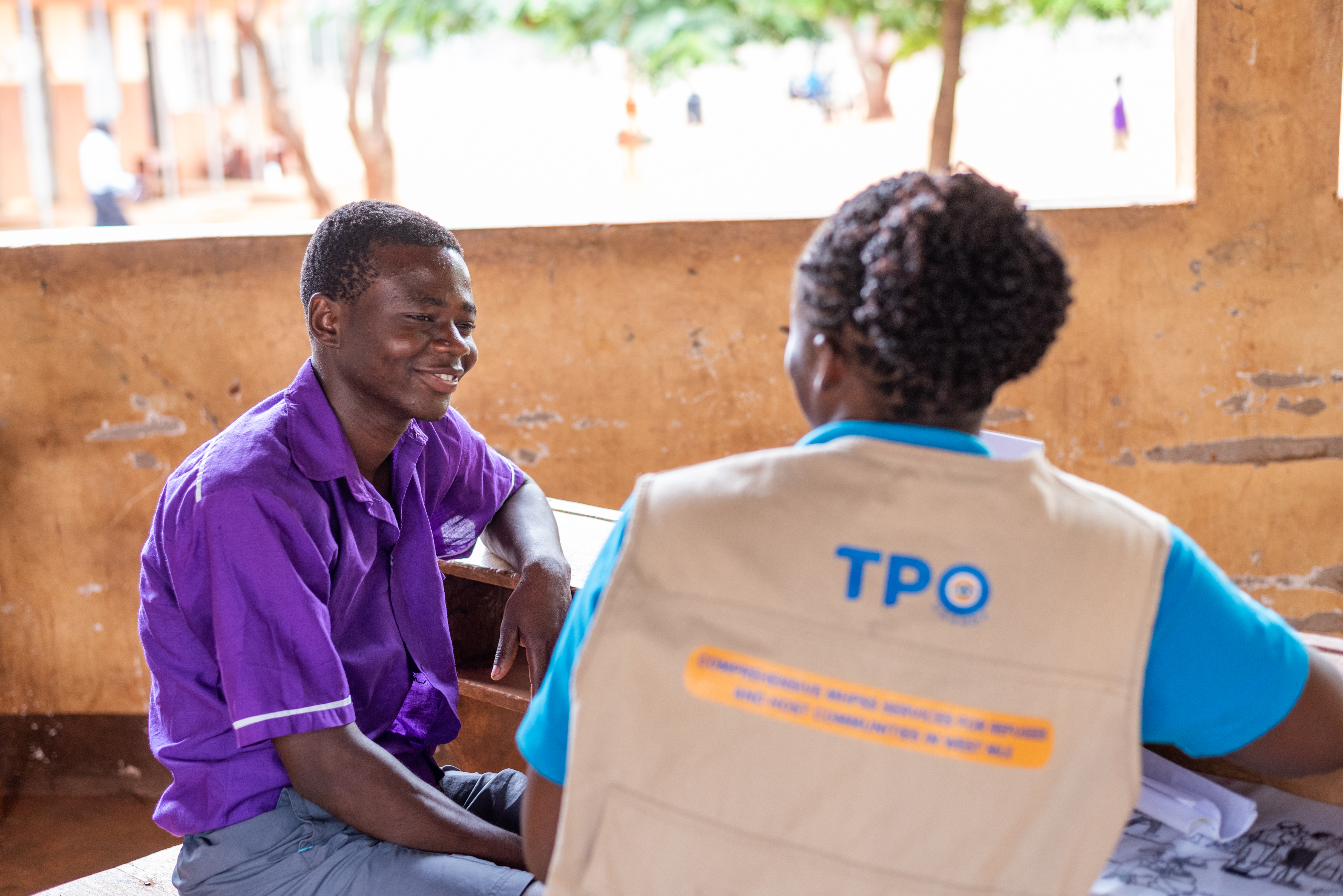 A care giver sharing a light moment with a TPO Clinical Psychologist after a joint visit