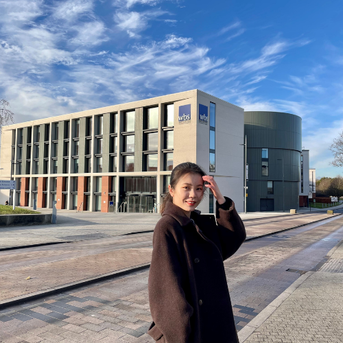 Xinwei standing outside Warwick Business School