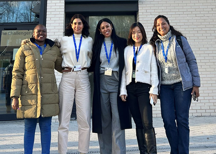 Zoë Mabie standing with fellow Warwick Business School MBA students outside a campus building.
