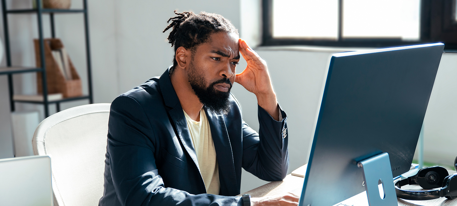 Small Business owner holds his head as he looks at a computer screen Small Business owner holds his head as he looks at a computer screen