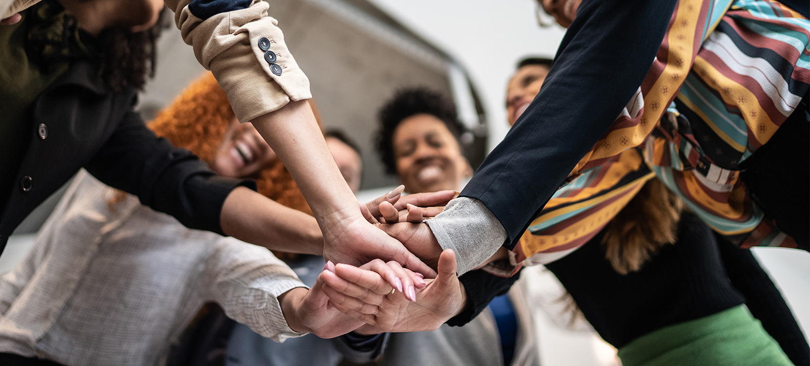 A group of professionals from different backgrounds huddle up like a team to illustrate prosocial co-operation. A group of professionals from different backgrounds huddle up like a team to illustrate prosocial co-operation.