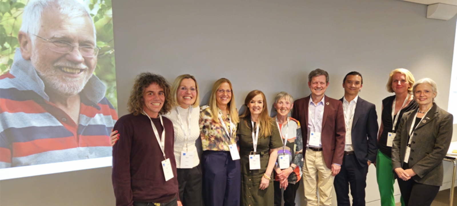 The Wensley family with friends and academics next to a picture of Robin Wensley The Wensley family with friends and academics next to a picture of Robin Wensley