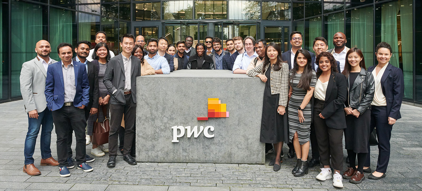 MBA students standing outside the offices of PwC MBA students standing outside the offices of PwC