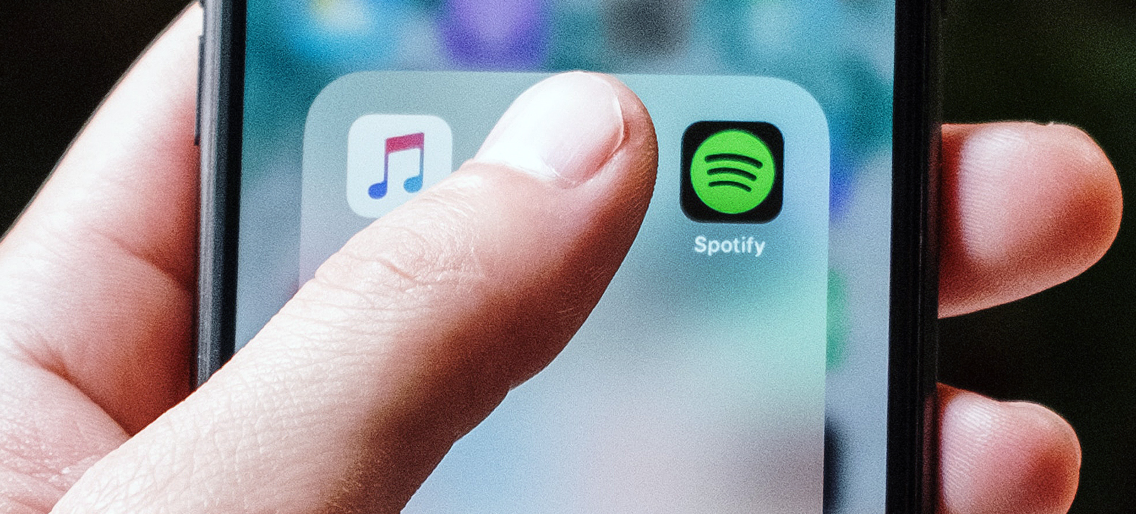 A smartphone user selects the Spotify app.