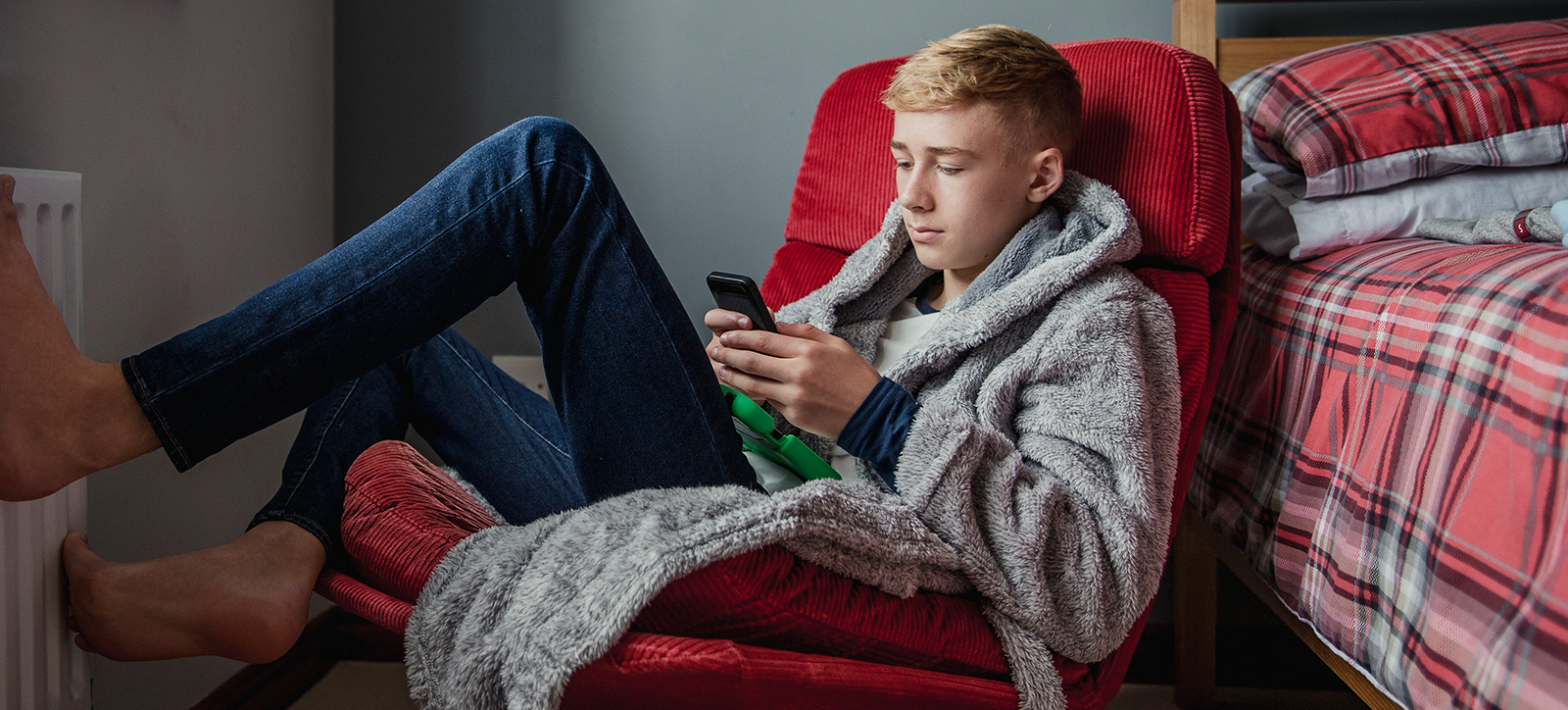 A boy scrolling through social media on his phone