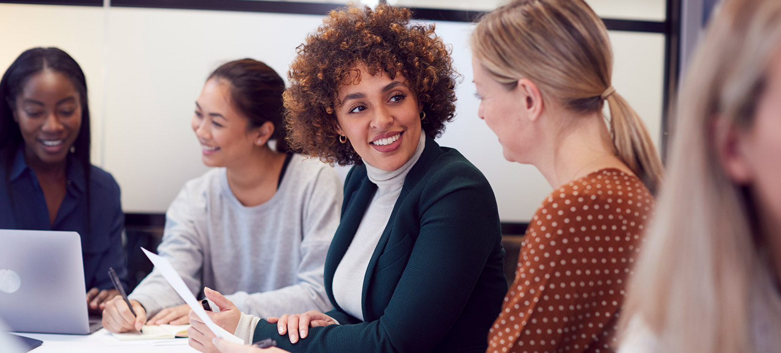 Group Of Businesswomen Collaborating In Creative Meeting Around Table In Modern Office