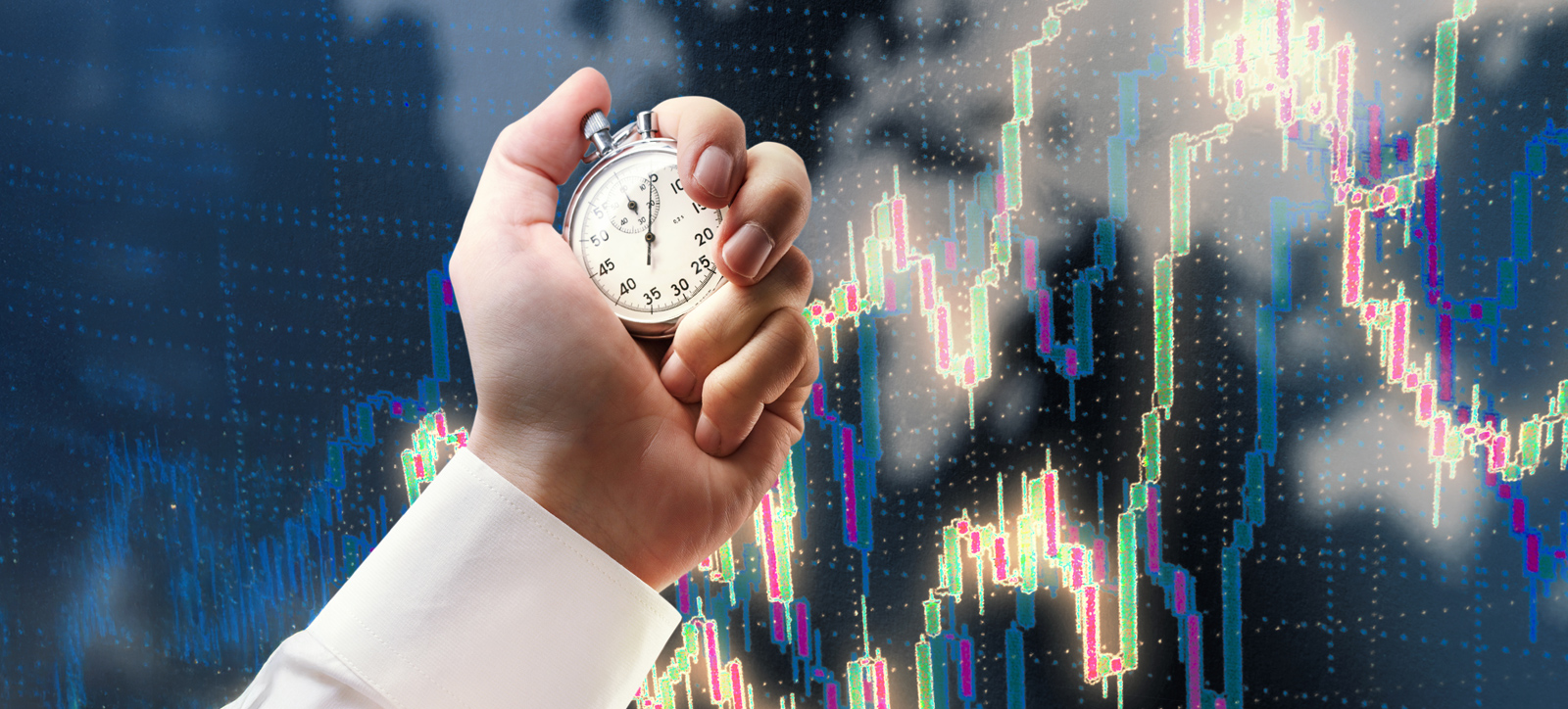A close-up photograph of a businessperson's hand holding a stop watch. The backdrop are digital graphs tracking financial performance on the markets. A close-up photograph of a businessperson's hand holding a stop watch. The backdrop are digital graphs tracking financial performance on the markets.