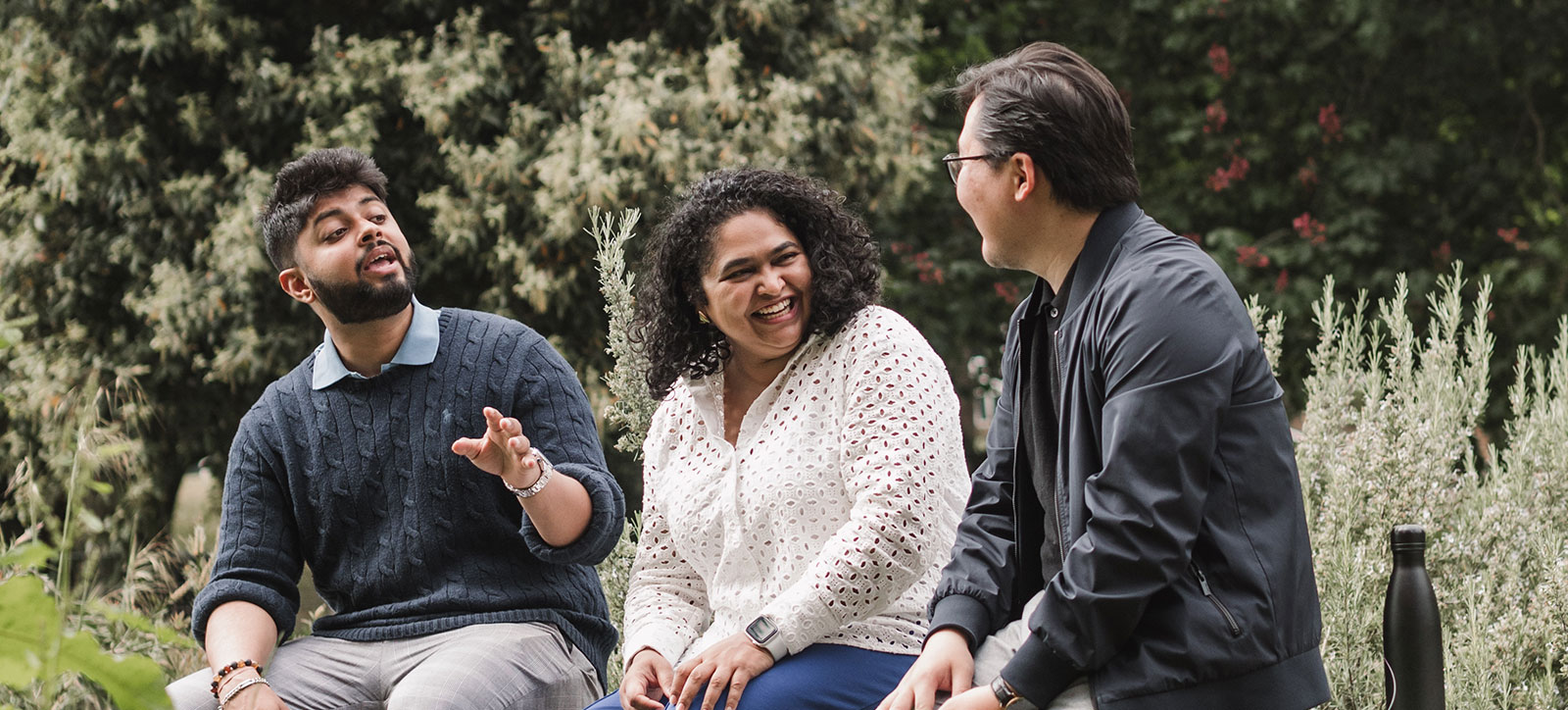 Three happy Warwick Business School MBA students discuss sustainability, two men and a woman