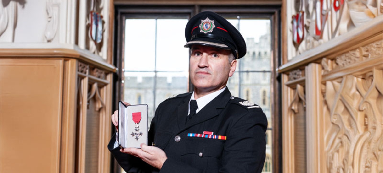 Fire chief Paul Murphy holding his MBE in his uniform Fire chief Paul Murphy holding his MBE in his uniform