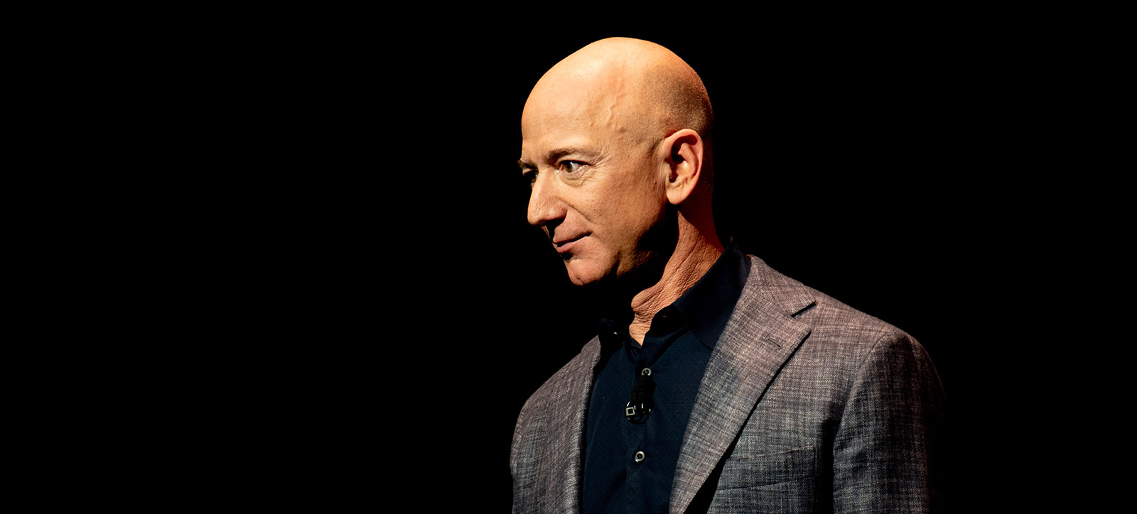 A photograph of Amazon founder Jeff Bezos on stage against a dark backdrop. Photograph credited to Daniel Oberhaus, 2019 A photograph of Amazon founder Jeff Bezos on stage against a dark backdrop. Photograph credited to Daniel Oberhaus, 2019