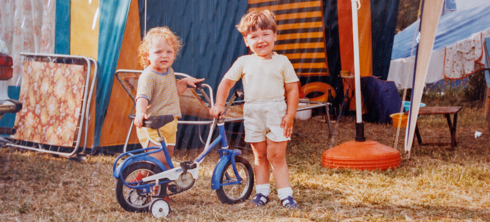 Two children with a bike on a camping trip in the 1970s