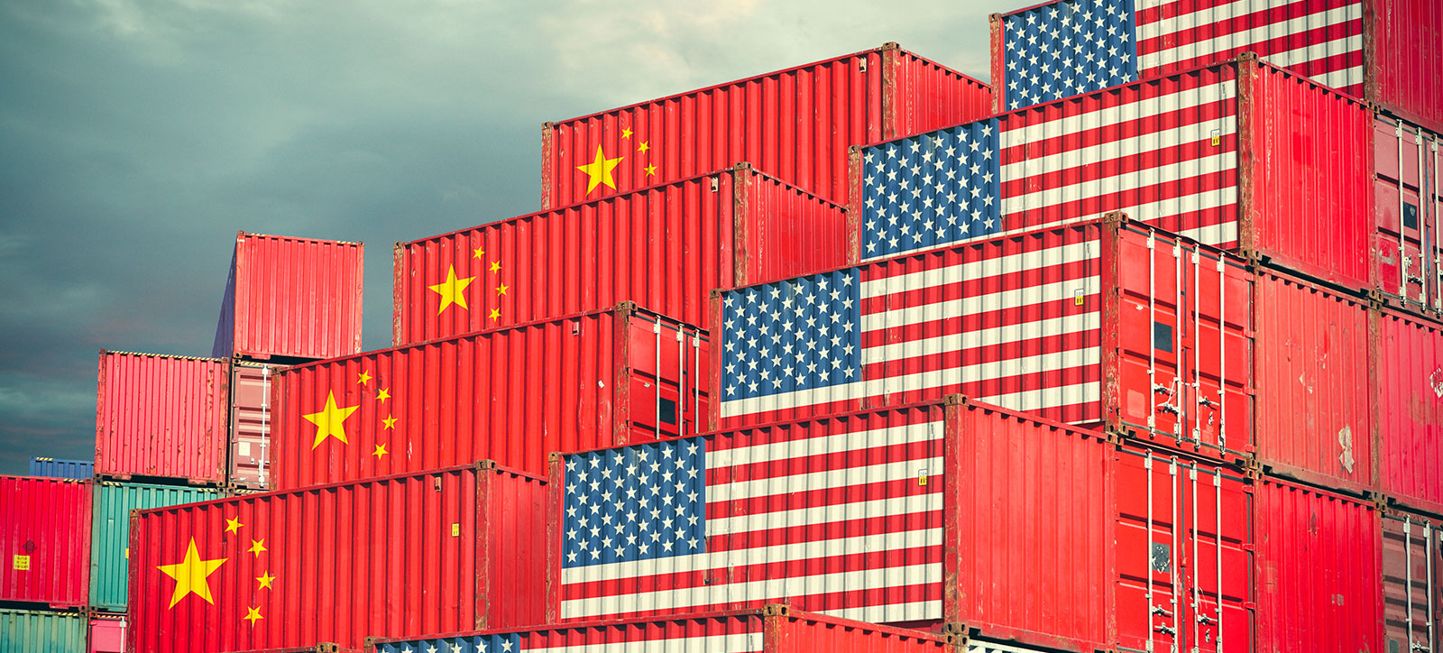 Two stacks of shipping containers. One stack bears the US flag, the other bears the Chinese flag. Two stacks of shipping containers. One stack bears the US flag, the other bears the Chinese flag.