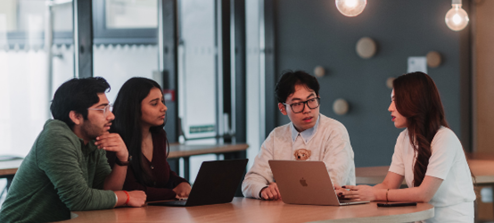 Masters in Finance students with their laptops and chatting outside at WBS