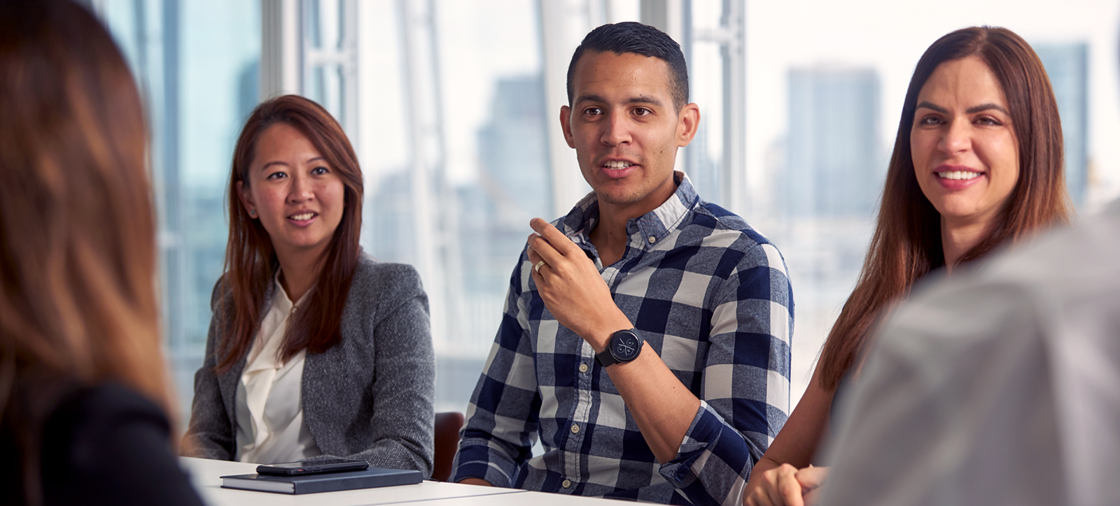 Five people seated at a table, actively discussing and exchanging thoughts in a collaborative atmosphere. Five people seated at a table, actively discussing and exchanging thoughts in a collaborative atmosphere.