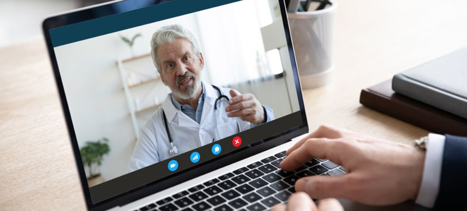 A GP on a laptop screen giving advice A GP on a laptop screen giving advice