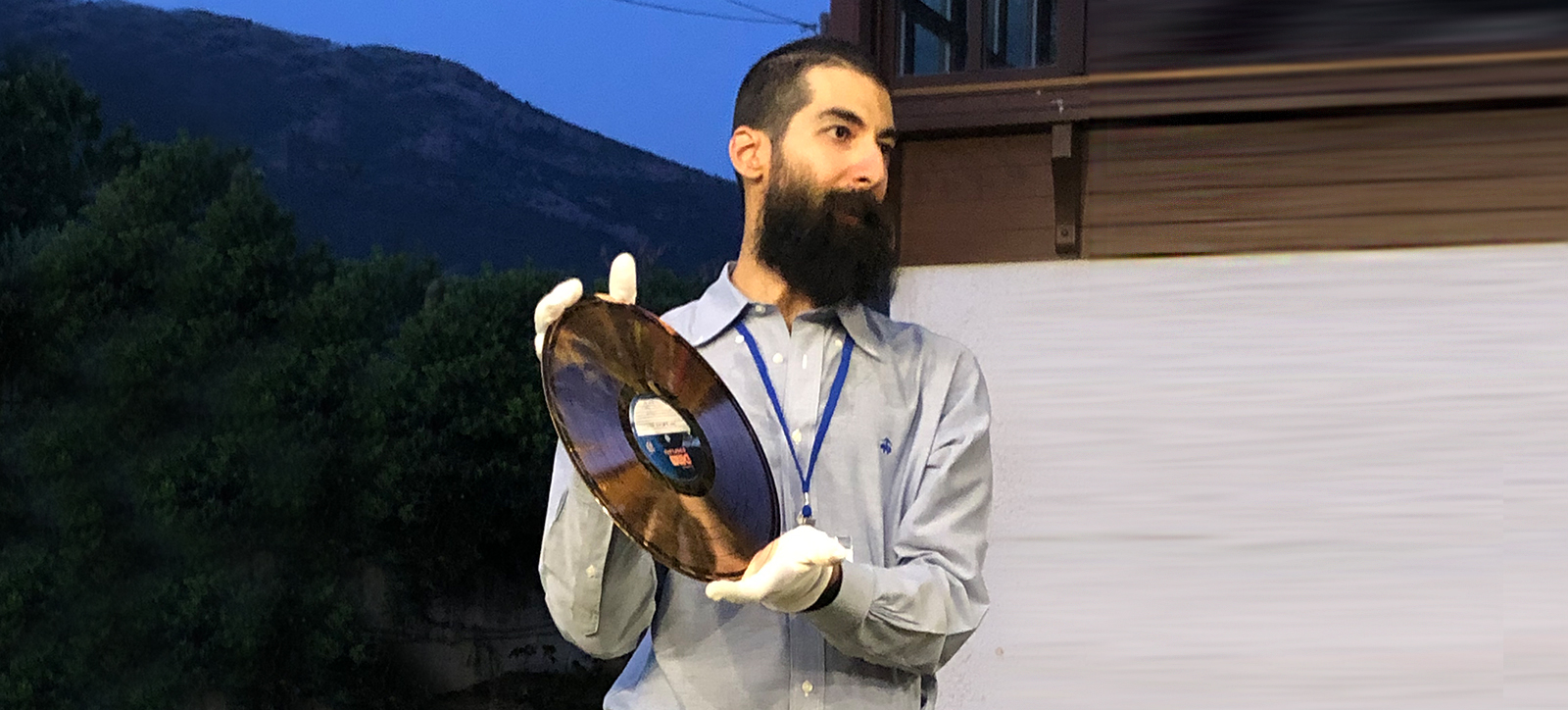 Man holding a copper record that he has just pressed