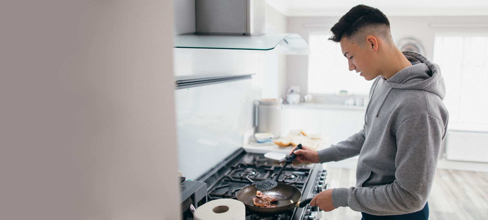 A teenage care leaver cooks for themselves in their own accommodation.