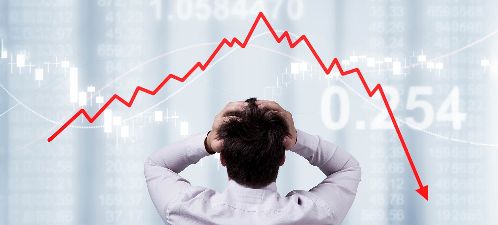 A trader watches in despair, with their hands on their heads, as they watch a plummeting read line illustrate the falling value of their stocks and shares A trader watches in despair, with their hands on their heads, as they watch a plummeting read line illustrate the falling value of their stocks and shares