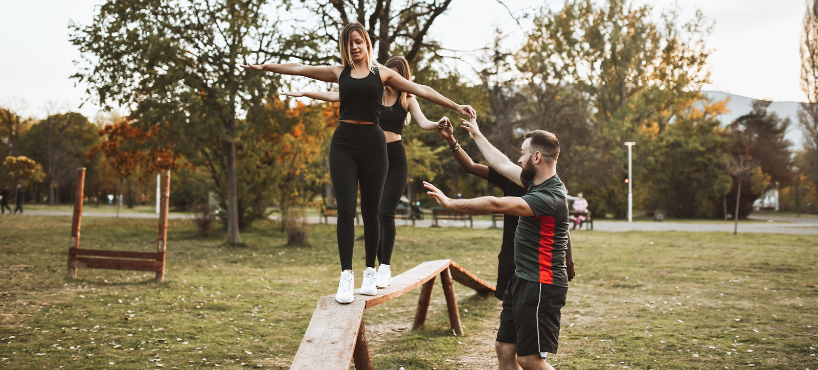 Colleagues cross a balance beam as part of a team building exercise Colleagues cross a balance beam as part of a team building exercise