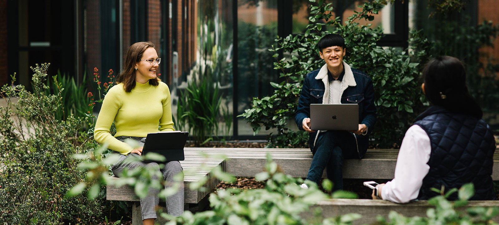 Masters in Finance students with their laptops and chatting outside at WBS