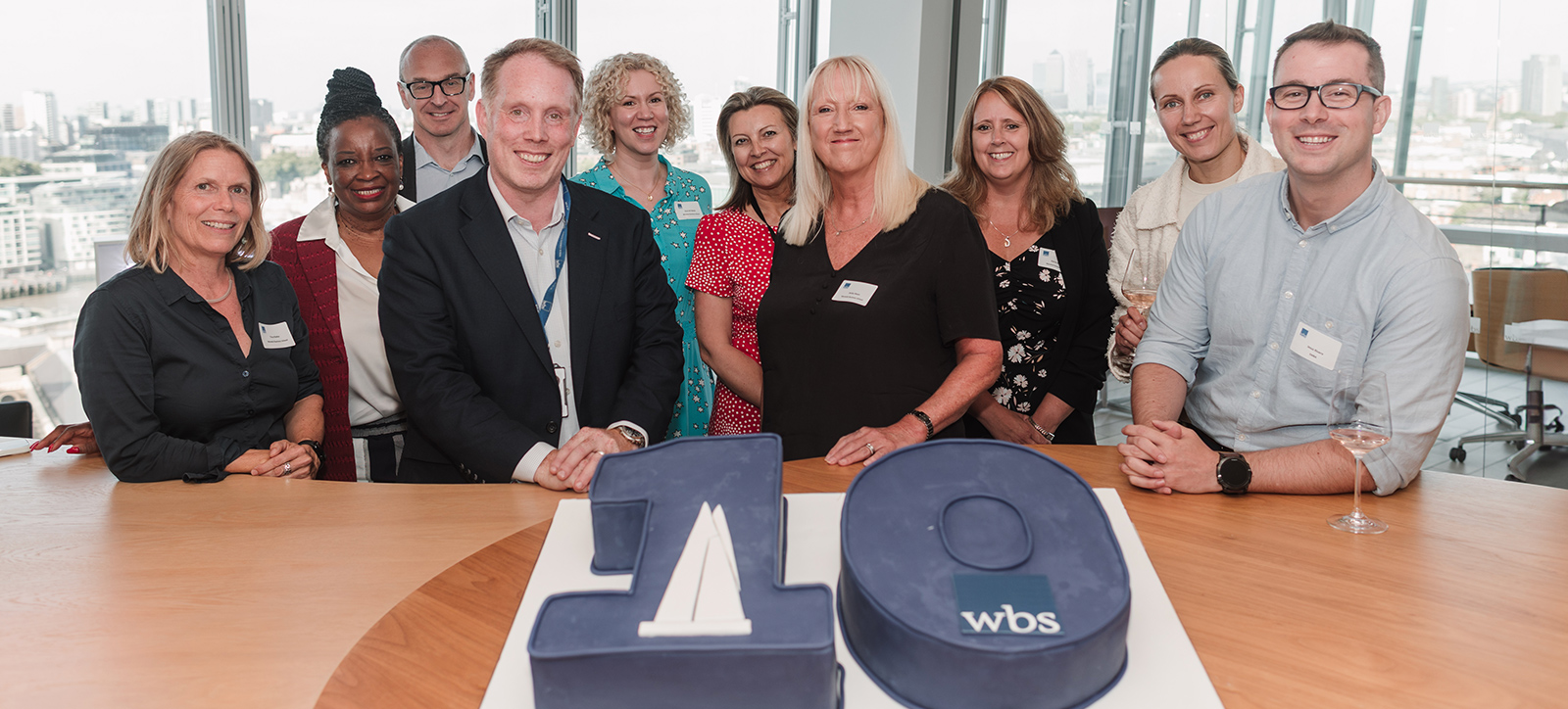Pro-Deans Ross Ritchie and Jacky Swan in front of a giant birthday cake and surrounded by staff, alumni and academics