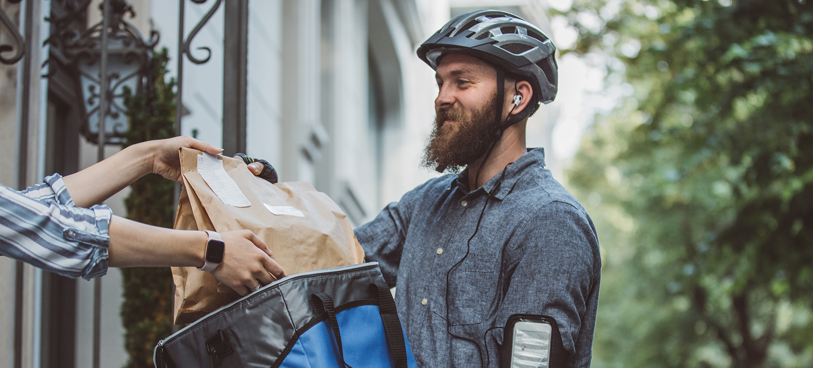 A deliveroo rider delivering a meal at a house A deliveroo rider delivering a meal at a house
