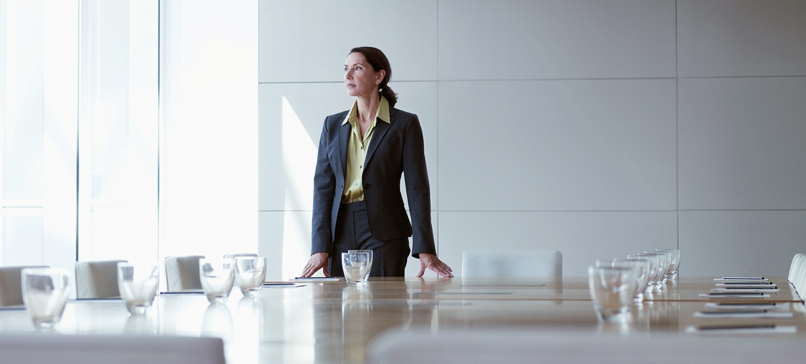 A female entrepreneur stands in an empty boardroom
