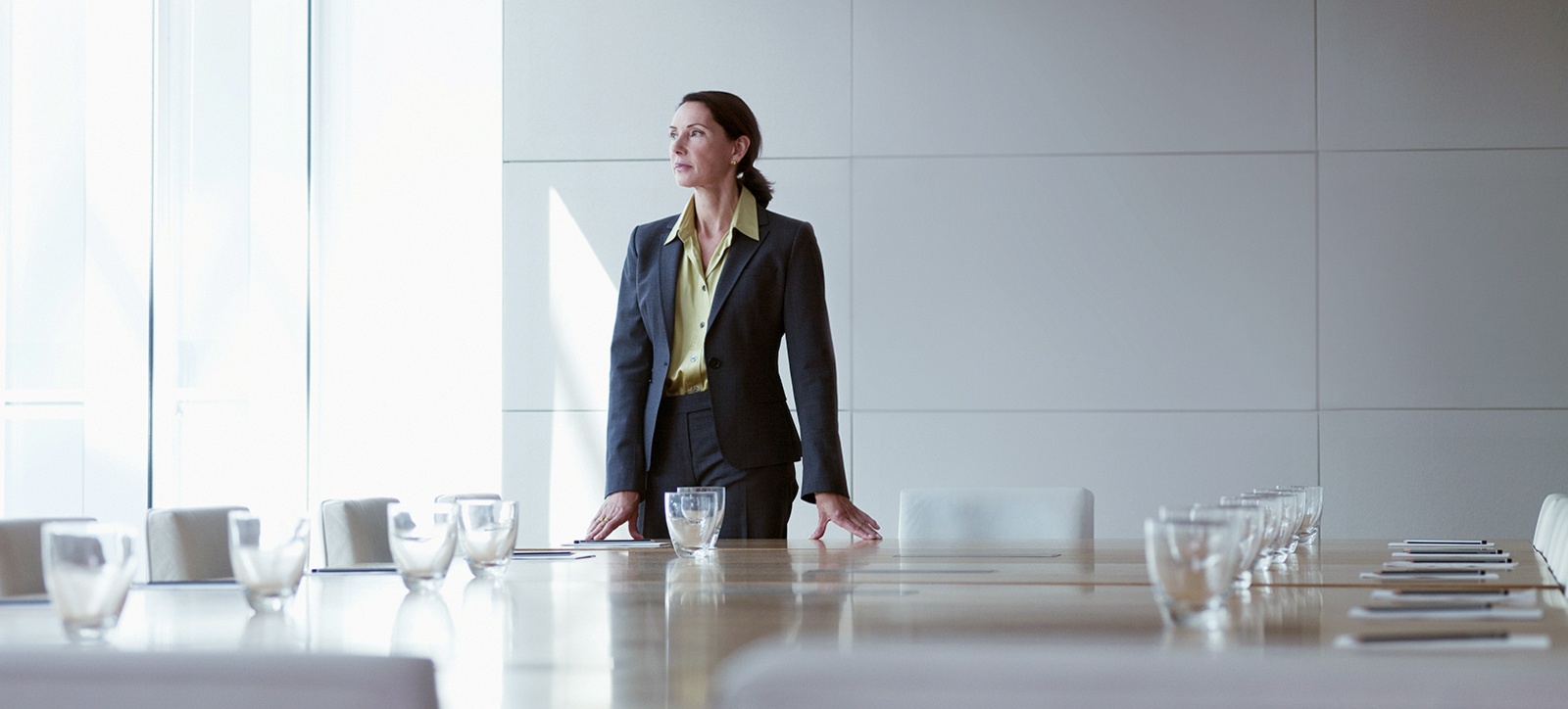 A female entrepreneur stands in an empty boardroom A female entrepreneur stands in an empty boardroom
